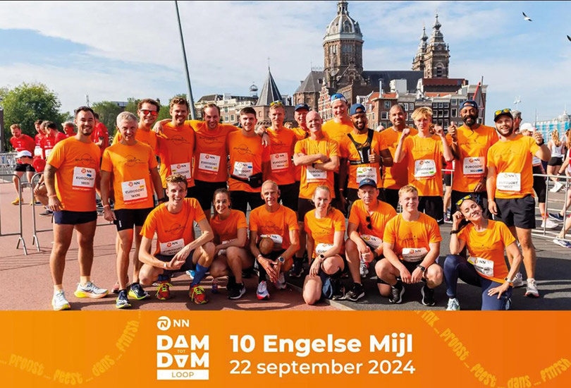 Group photo of EuroSort's runners in the 10 mile run in Amsterdam. all wearing orange shirts